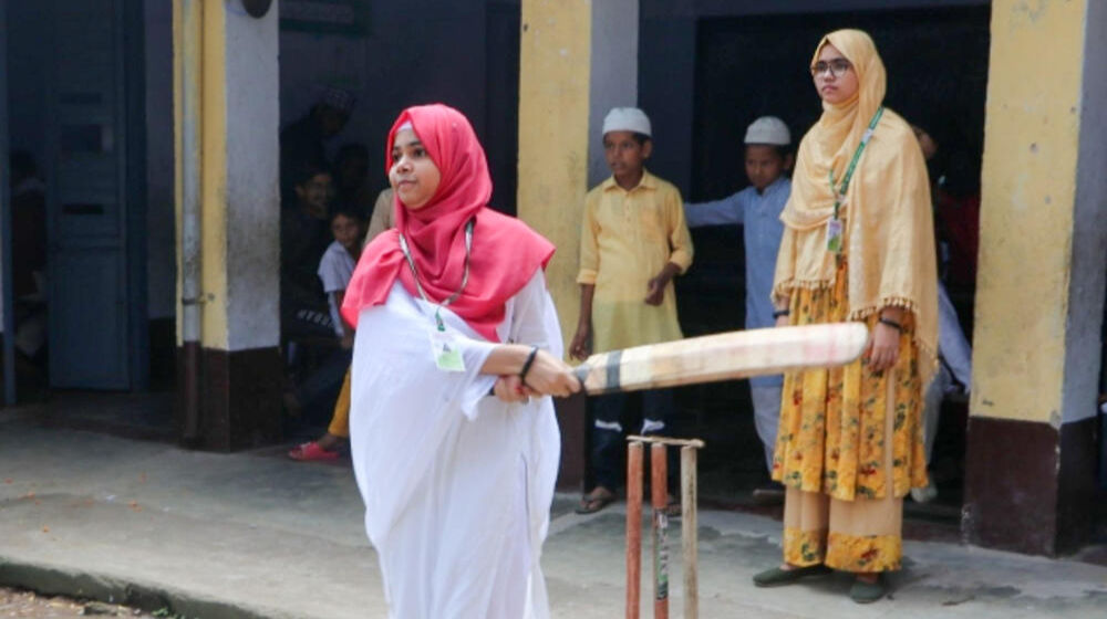 A 15-year-old girl swings a cricket bat