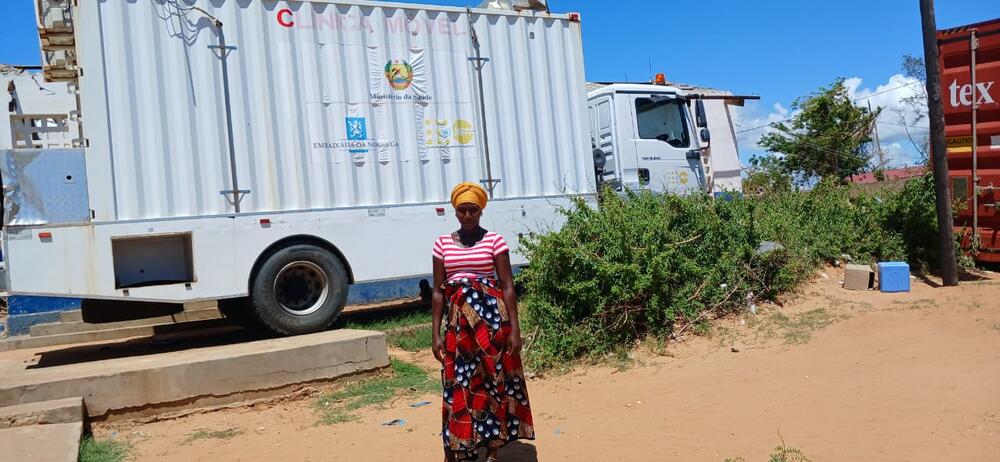  A pregnant woman stands in front of a truck