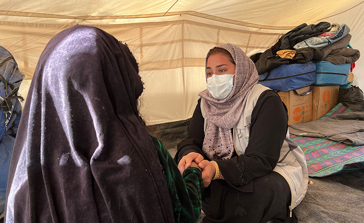 Counselor consoles and holds hands with a survivor.