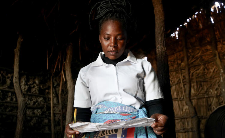 A nurse looks down at a sheet of paper.