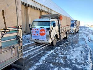 A supply truck sits on an icy road. 