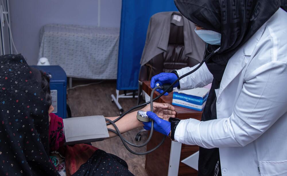 A medical worker records a patient's blood pressure.