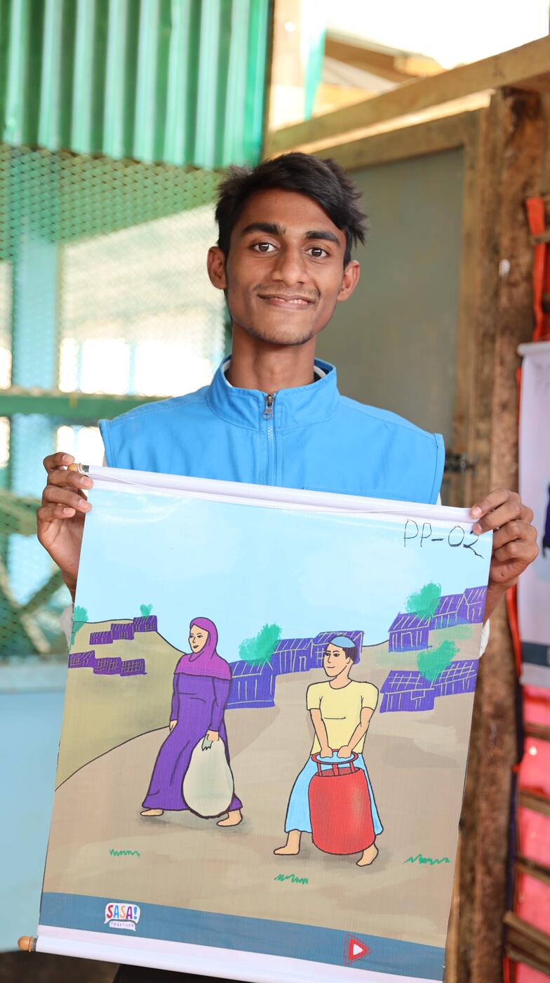 A young man holds a poster.