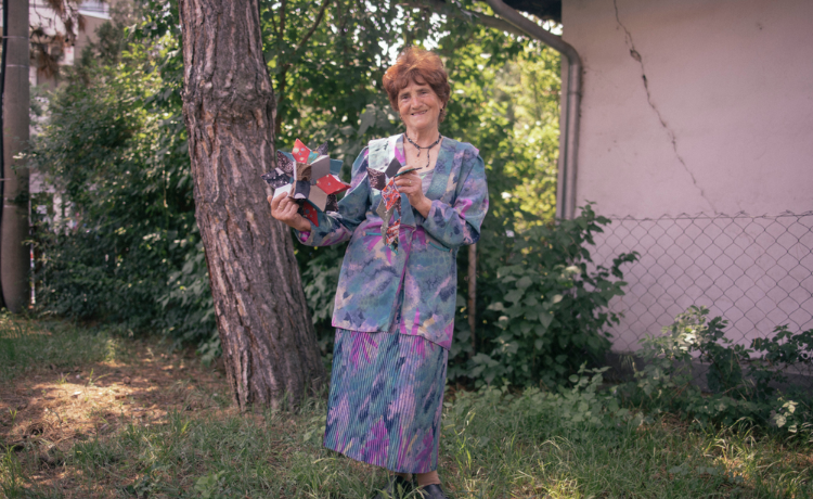  A woman stands holding folded paper stars.