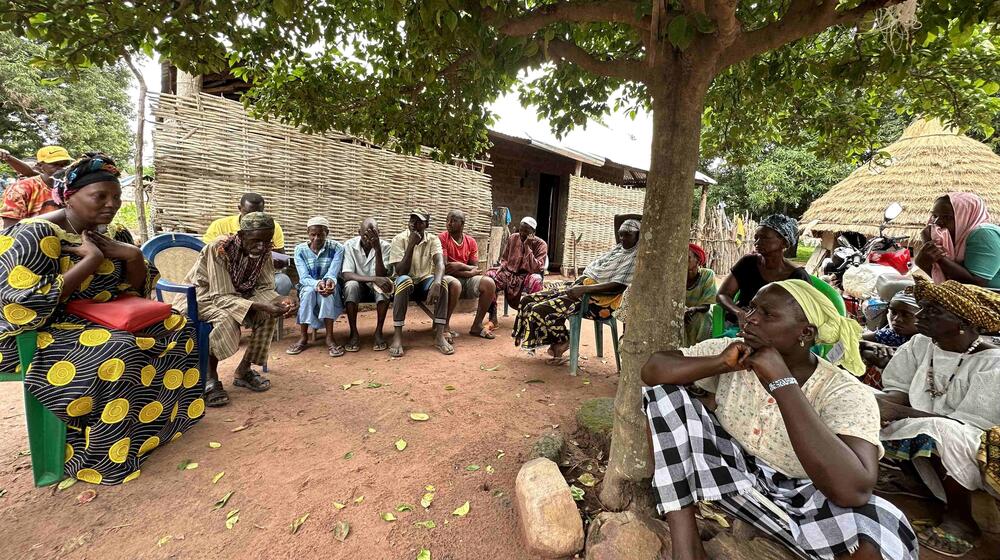 Un groupe de personnes est assis en cercle autour d’une intervenante.