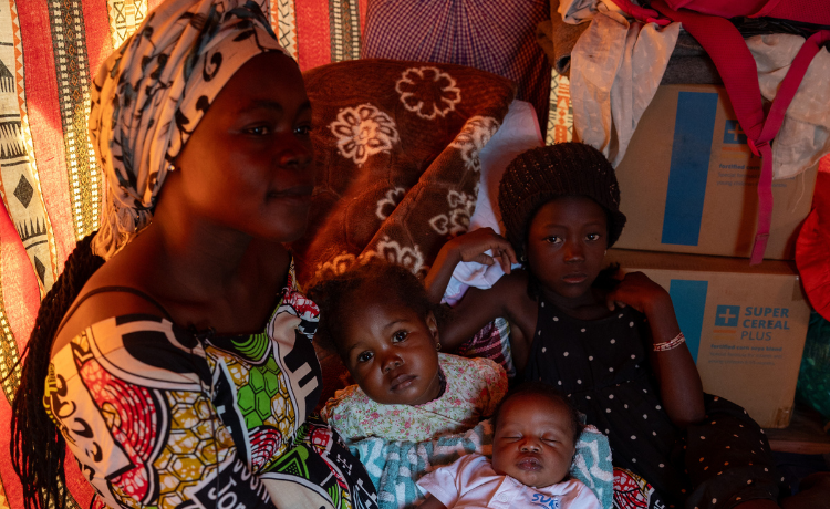 Mother smiles while holding her children