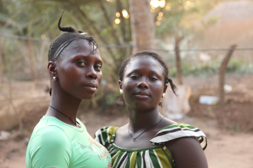 Deux jeunes filles regardent droit dans l'objectif de l’appareil.