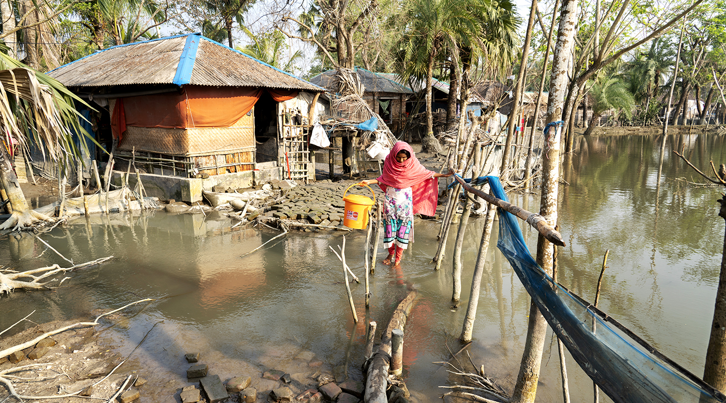 Farzana patauge dans l’eau des inondations à Uttar-Bedkashi, dans le district de Khulna.