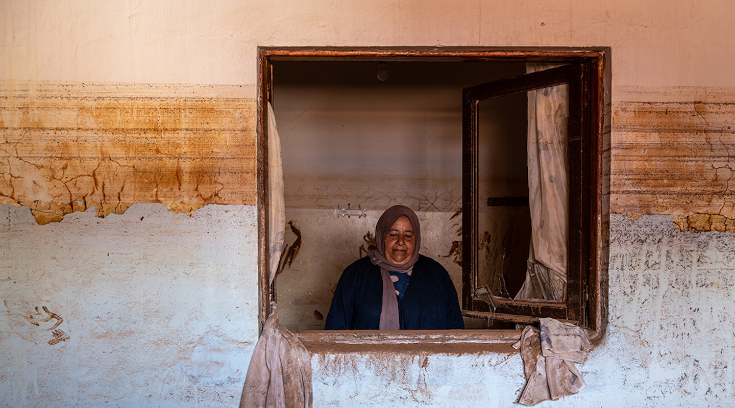 Une femme à la fenêtre d’une maison inondée à Gandula.