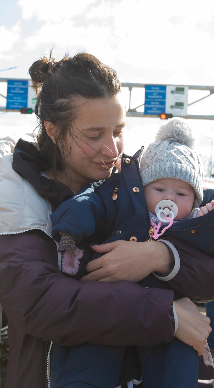 A mother holds her young child. 