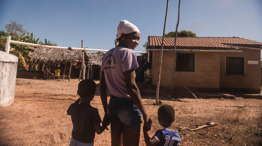 A woman walks with two children. 