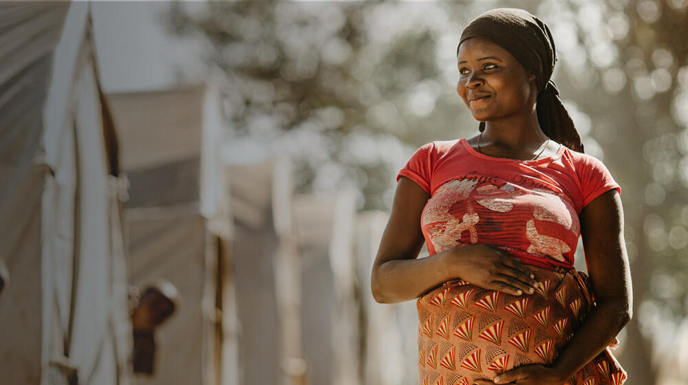 A pregnant woman smiles. 