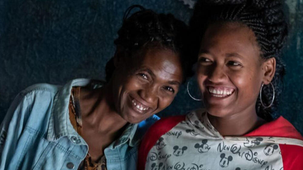 Two women smile together.